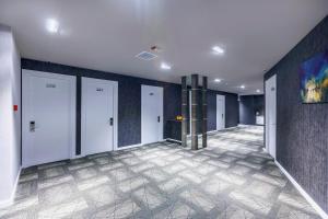a hallway with four doors and a tile floor at Parallel Hotel in Baku