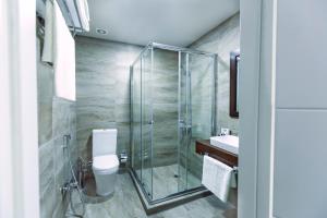 a bathroom with a shower and a toilet and a sink at Parallel Hotel in Baku