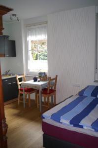 a bedroom with a bed and a table and chairs at Pension Oberberg in Lindlar