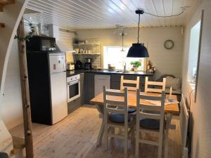 a kitchen with a table and chairs and a refrigerator at Stallet - Hemma hos Mait in Mora