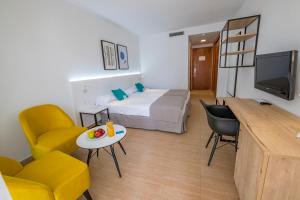 a small room with a bed and a table and chairs at DWO Sirius - Adults Only in Santa Susanna