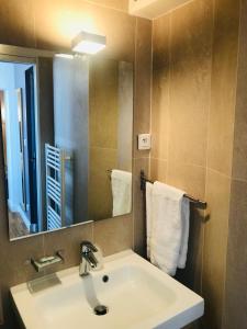 a bathroom with a sink and a mirror and towels at Hotel de L'Union in Paris