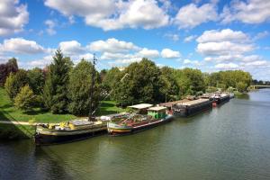 Un grupo de barcos están atracados en un río. en Bateau péniche au coeur de Lille, en Lille