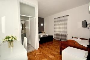a room with a bedroom with a bed and a mirror at Guesthouse Kamen Kuća in Podstrana