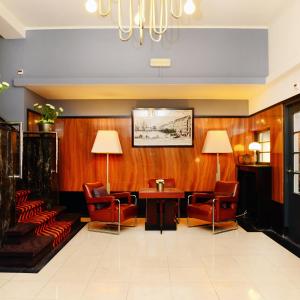 uma sala de espera com cadeiras, uma mesa e um lustre em Amrâth Hotel DuCasque em Maastricht