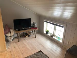 a living room with a flat screen tv and a table at Stallet - Hemma hos Mait in Mora