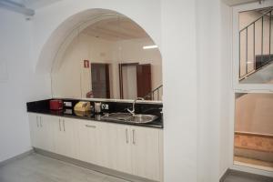 een keuken met een wastafel en een spiegel bij Vivian's Guest House in Jerez de la Frontera