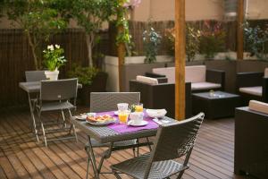 een tafel en stoelen met eten op een patio bij Blanc Guest House in Barcelona