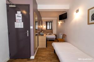 Habitación con 2 camas y puerta con dormitorio en Hotel de L'Union en París