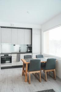a kitchen with a wooden table and chairs in a kitchen at Tunturinlaita D3 in Levi +18 photos
