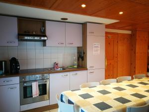 a kitchen with white cabinets and a table with chairs at Haus Bünten in Quinten