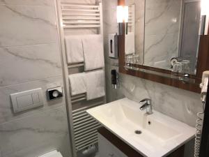 bagno con lavandino e specchio di Hotel König a Vienna