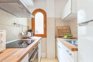 a kitchen with white appliances and a window at APARTAMENTO EL ROJO in Can Picafort +13 photos
