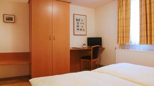 a bedroom with a bed and a desk with a computer at Hotel Deutsches Haus in Kaub