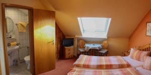 a bedroom with two beds and a bathroom with a window at Gästehaus Eberlein in Rothenburg ob der Tauber