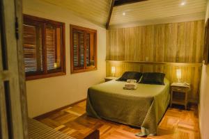 um quarto com uma cama e piso em madeira em Espaço Tajj em São Roque