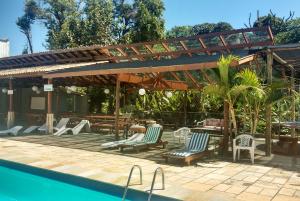 a patio with chairs and a table and a pool at Hotel Santiago in Lindóia