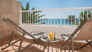 un tavolo e sedie su un balcone con vista sull'oceano di Be Live Adults Only La Cala Boutique Hotel a Palma de Mallorca