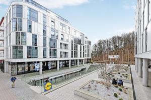 duży budynek z ludźmi stojącymi przed nim w obiekcie Dom & House - Apartments Baltiq Plaza w mieście Gdynia