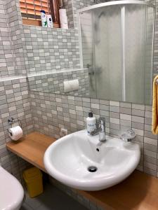 ein Badezimmer mit einem weißen Waschbecken und einem WC in der Unterkunft Apartman Kadic in Bjelašnica