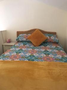 a bed with a floral bedspread and a pillow on it at The Croft Accommodation in Gamrie