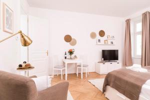 biały salon z łóżkiem i stołem w obiekcie Heart of Ottakring w Wiedniu