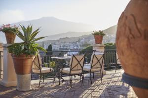 a patio with chairs and a table on a balcony at Grand Hotel Timeo, A Belmond Hotel, Taormina in Taormina
