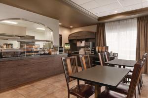a kitchen with tables and chairs in a restaurant at Days Inn by Wyndham Levis in Lévis