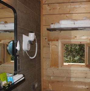 La salle de bains est pourvue d'un miroir, d'un lavabo et d'une fenêtre. dans l'établissement Les Cabanes Dans Les Bois Logis Hôtel, à Villedubert