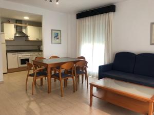 uma sala de estar com uma mesa e cadeiras e um sofá em La Riviera - Serviden em Denia