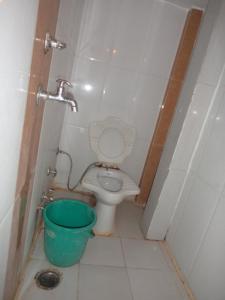a small bathroom with a toilet and a bucket at HOTEL NEELKAMAL in Indore
