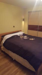 Una cama con una manta negra con flores. en Willow house Eircode F92V67T No kitchen no washing machine at this time available, en Letterkenny