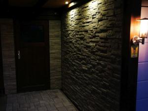 ein dunkles Zimmer mit einer Ziegelwand und einer Tür in der Unterkunft Ferienwohnung am Silberg in Plettenberg