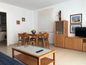 een woonkamer met een tafel en een televisie bij La Fontana - Serviden in Denia