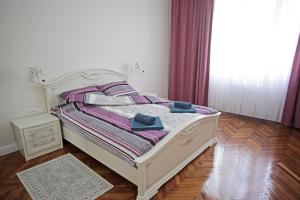 a white bed with two blue towels sitting on it at City Center Belgrade Queen Apartment Skadarlija in Belgrade