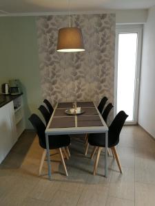 mesa de comedor con sillas negras y lámpara en Gästewohnung Hygge, en Oldenburg