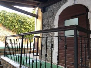 einen Balkon mit einem schwarzen Geländer und einem Fenster in der Unterkunft Apartman "Ela" in Fužine