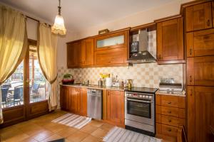 a kitchen with wooden cabinets and a stove at Luxury Villa Helios in Koropi