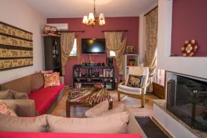 a living room with a couch and a fireplace at Luxury Villa Helios in Koropi