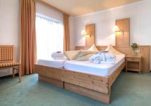 a hotel room with a bed and a night stand at Hotel Nassereinerhof in Sankt Anton am Arlberg