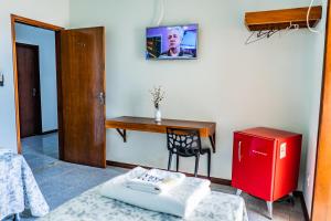 a room with a desk and a table and a chair at Pousada Paraiso in Guanamby