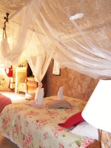 een slaapkamer met een hemelbed bij Troglodelice in Azay-le-Rideau
