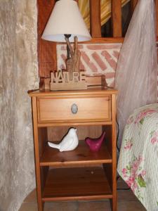 - une table de chevet avec une lampe et une nativité dans l'établissement Troglodelice, à Azay-le-Rideau