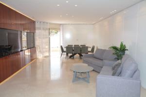 a living room with a couch and a table at Renovated 3 Bedroom - Residence with Pool next the Beach in Eilat