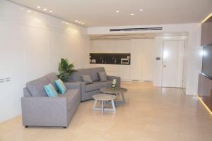 ein Wohnzimmer mit einem Sofa und einem Tisch in der Unterkunft Renovated 3 Bedroom - Residence with Pool next the Beach in Eilat