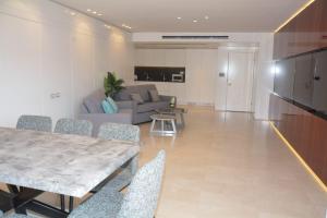 a living room with a table and a couch at Renovated 3 Bedroom - Residence with Pool next the Beach in Eilat