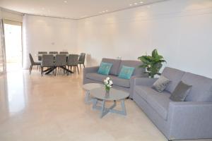 a living room with a couch and a table at Renovated 3 Bedroom - Residence with Pool next the Beach in Eilat