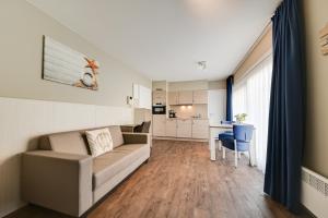 a living room with a couch and a table at Holiday Suites De Haan in De Haan