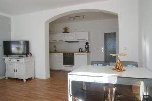 a kitchen and dining room with a table and a tv at Ferienwohnung Häckel in Kurort Oberwiesenthal