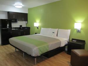 a bedroom with a large bed and a green wall at Studio 6 Colorado Springs, Colorado - Air Force Academy in Colorado Springs